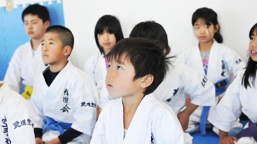 正座で先生の話に耳を傾ける子供たち